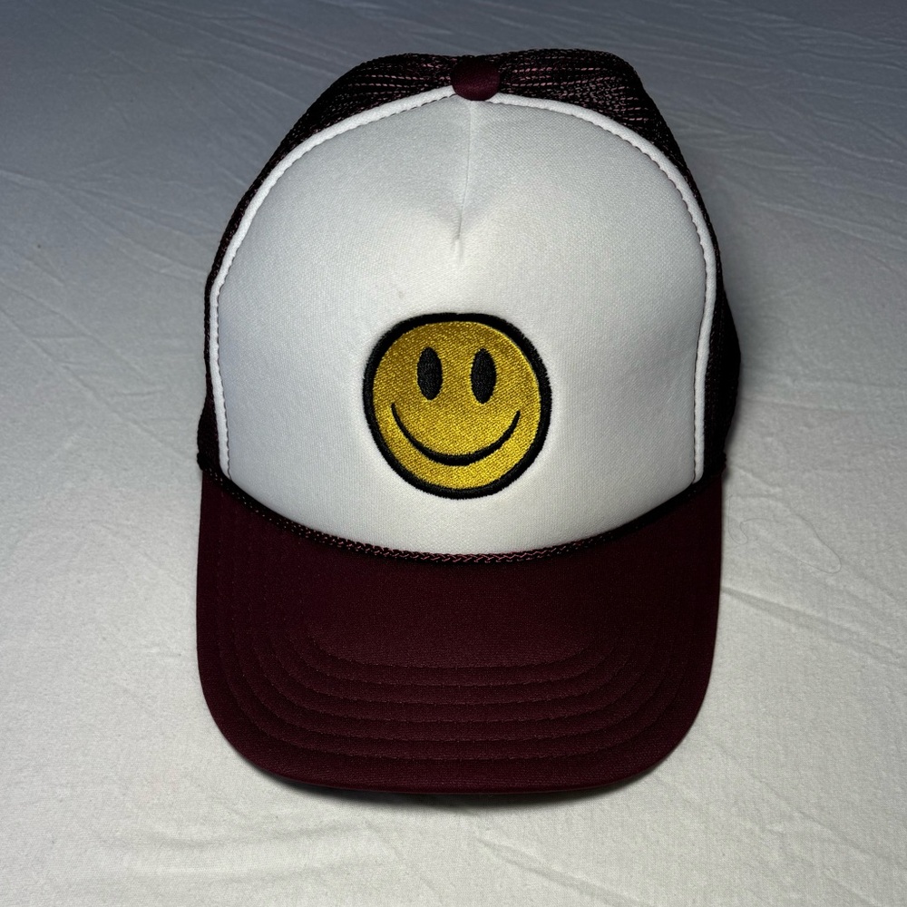 White and burgundy smiley face trucker hat